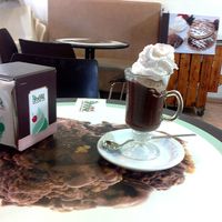 A hot Cioccolata with a cold Snickers Snack Soy-based Ice-Cream inside it and a Whipped Cream upon it, all Vegan. at Grande Italia in Rehovot