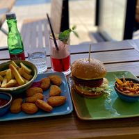 Falafel burger with deep fried carrot shavings and nuggets with seasoned fries. + virgin fruity cocktail 😎 at King's Caffe in Malinska