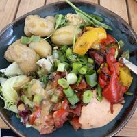 This was a vegan bowl, on the bottom baby spinach and topped with hummus, guacamole, and some kind of aioli, pumpkin seeds, green onions, baby potatoes and grilled peppers.  at Café & Bar Celona - Wandsbek in Hamburg