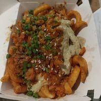 Kimchi fries: curly fries with green onions, sesame seeds, vegan sauce & vinegar at Anti Burger in Panama City