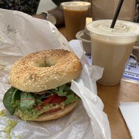 Bagel with guac and bell pepper and smoothie, coffee in the back.   at Big Bad Bagels - Baznicas in Riga
