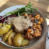 Baked potatos, hummus, salad and curried cauliflower bowl  at püük - fein + herausgeputzt in Hamburg