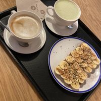 Breakfast! Oat latte, matcha latte and tostada with tahini and banana. Amazing! at Curcuma Green Food in Burgos