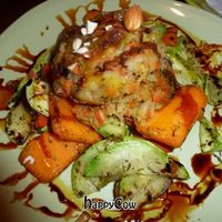 Vegan burger served on a bed of baked root vegetables, sprinkled with almonds.   at Earth Cafe - Derb Zawak in Marrakech