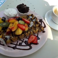 Vegan waffles with coconut cream, plum jam and chocolate sauce (and a flat white). at Cakester Cafe in Krakow