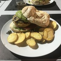 Hamburguesa vegana de garbanzos, con guacamole, champiñones, tomates y cebolla caramelizada. Esta bien. El pan es casero y las patatas también (están muy buenas).  at Rancho Chico in Suances