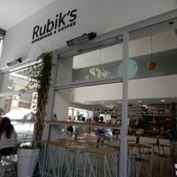 sitting in the outdoor cafe area at Rubik's Superfood & Coffee in Patras