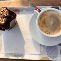 Chocolate and gooey caramel muffin, coffee with oat milk  at Pasteleria Serra in Gandia