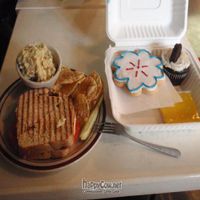 Pesto and vegan mozzarella panini. Sugar cookie, lemon square and cookies n' cream cupcake. at Sweetpea Baking Company in Portland