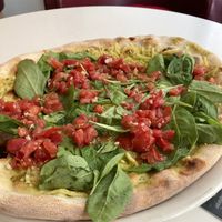 Vegan Pizza with basil pesto, vegan cheese, spinach & tomatoes at Vapiano in Linz