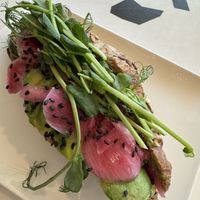 Wholemeal croissant filled with avocado, pickled onion and pea shoots.  at Puistokahvila Makia in Oulu