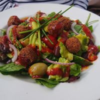 Falafel salad with cherry tomatoes, cucumber, red onion, olives, avocado, rocket and red pepper dressing. at Cafe Mylor in Falmouth