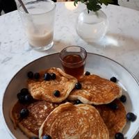 Vegan pancakes with maple syrup and half empty cafe latte with oat milk at Green Hippo in Helsinki