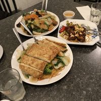Duck (in front), Buddha’s special on crispy noodle (back left), kung pao chicken (half eaten, back right) at Buddha's Vegan Restaurant in Toronto