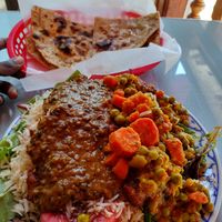 Dal makhani & veggie korma over fried potato pakoras, watermelon, basmati rice & salad. Topped w tamarind chutney. Yumm at Jotmahal in Berkeley