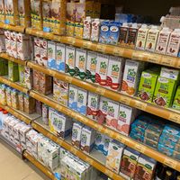 A whole wall of non dairy milks 💚 at Naturalia - Bezons in Courbevoie