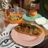 Reuben hot dog, nachos (already started on) & chicken burger!! at Genesis Plant Based Alchemy in North London