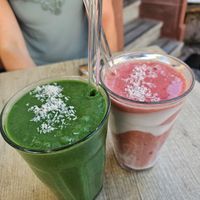 Smoothies (6.50): spirulina, mango, spinach, banana, coconut rice milk (green); Coconut milk, strawberries, banana, dates, coconut yoghurt (red/white) at Cafe Nomad - Weststadt in Heidelberg