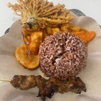 Brown rice ball with potatoes, sweet and sour veggies and fried veggies.   at Vegan House in Jakarta