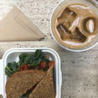 Sandwich with cashew cheese, kale and cherry tomatoes. Iced coldbrew latte. at Mora Mora - Roma in Mexico City