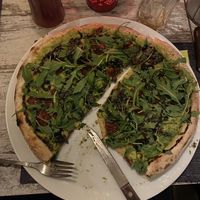 Pizza Vegana - grüner Hummus, getrocknete Tomaten, Oliven, Basilikum-Pesto, Ruccola #Veganuary at Kennidi in Kaprun