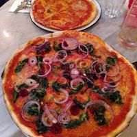 Special pizza with cranberry dressing (front) and delicious 'prosciutto' - quite salty, as it should be (back) at Pizza Express - Aldwych in London