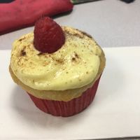 Vanilla cupcake, cream cheese frosting, cinnamon, and a fresh raspberry on top! at The Baked Vegan Bakery in Lake Park