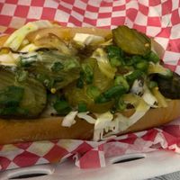 Vegan brat topped with slaw, onions, and pickles at Blue Sage Vegan Bistro in Little Rock