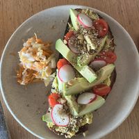 Avo on toast - Sourdough with sweetcorn spread, avocado, cherry tomatoes, radish, macadamia dukkah and kraut on the side  at Felix For Goodness in Brisbane