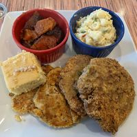 Large plate with crab cakes, fried chicken, potato salad, yams, cornbread at VelTree in Charlotte