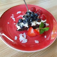 deeply chocolatey vegan cake with cream and fruit at Strh Cafe & Gallery in Zakopane