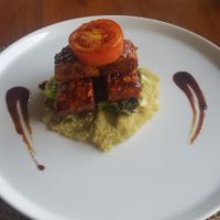 Vegan Ribs (Grilled marinated tempeh on barbecue sauce served with garden mixed salad and mashed sweet potato) at Pissari Bali Cafe in Ubud