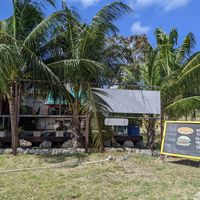 Lion's Share is located on a grassy lot across the road from a KFC. at Lion's Share Cafe in Bridgetown