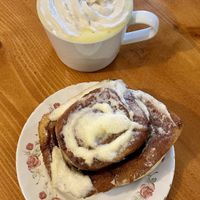 Turmeric latte w coconut whip and a huge cinnamon roll  at Fern Cafe and Bakery in Victoria