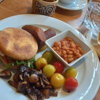 Muffin with vegan cheese, baked beans, grilled tomatoes and mushrooms and chickpea sausages at Palmovka in Prague