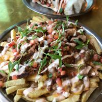 Classic Fries, asada style with burrito in the back at Modern Times Far West Lounge in Encinitas
