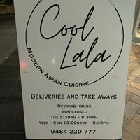 A-Frame sign on footpath; restaurant is off the street through the arcade and down some stairs at Cool Lala in Airlie Beach