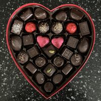 Vegan Silver Embossed Heart - 29 pc (16 oz). Includes includes soft creams, crunchy hazelnut selections, brasero and hazelnut ganaches, marzipan, cordial cherries, & more. at Rose City Chocolatier in Martinsburg