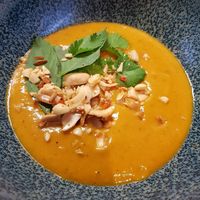 Take away - Red curry & smoked pumpkin soup, topped with roasted ginger/chili/garlic peanuts and fresh coriander & thai basil... It was as gorgeous as it looks 😍 at Bonboon in Amsterdam