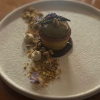 Geweldig dessert, pistache cakje met pistache crème op rode vruchten saus, met noten en lavendel crème  at Bonboon in Amsterdam