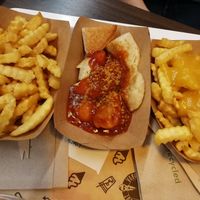 Patatas fritas, bratwurst y patatas con queso. Le pone curry a todo, demasiado curry para nuestro gusto. Si lo hubiéramos sabido pedíamos que no nos pusieran. 😵 at VINCENT - East Side Mall in Berlin