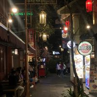 Street with eatery on the right and outdoor seating on the left  at Herbivore in Jakarta