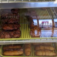 Awesomely apple fritters, in dessert case with cinnamon rolls at Vegan Donut-Gelato in Houston