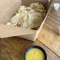 Chips and queso - huge box of chips with a small container of queso.  at Nissi Vegan in Austin