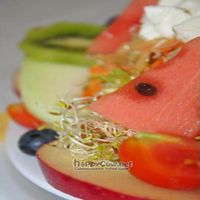 This is a house salad with a mild mustard dressing with fresh fruit, sprouts, tomatoes and mozzarella. 
 at Lei e Lui in Berlin