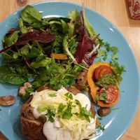 Baked potato topped with tamari mushrooms and peppers, pesto, vegan cheese and salad at Antiquity Plant-based Cafe @ The Timetravellers Bookshop in Skibbereen