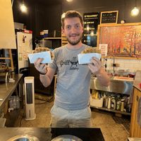 Owner's son with hot fresh waffles   at VeganWaf in Brussels