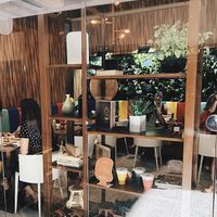 Dentro de galeria. Tem dois espaços frente a frente. Ambos com mesas e cadeiras confortáveis  at Manu Tenório Café in Recife