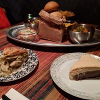 Clockwise from bottom left: Brown Butter Rosemary Apple pie, daikon slaw, BBQ jackfruit, rolls, yucca chips, jicama slaw, ancho chicken, and Whiskey Chocolate Cream pie. at Rood Food and Pie in Lakewood