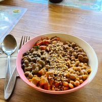 Bowl with black beans, chickpeas, sweet potato, tomatos, corn, quinoa. Toppen with peanut sauce at One Happy Bowl in Noord